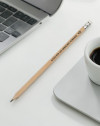 Lápiz de madera con mensaje sobre derechos humanos junto a portátil y taza de café